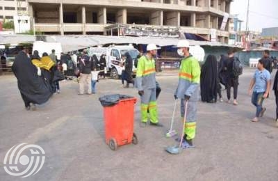 عمال بلدية من طهران ينظفون شوارع مدينة الكاظمية المقدسة